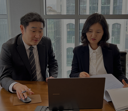 노트북과 서류를 보며 논의하는 두 사람